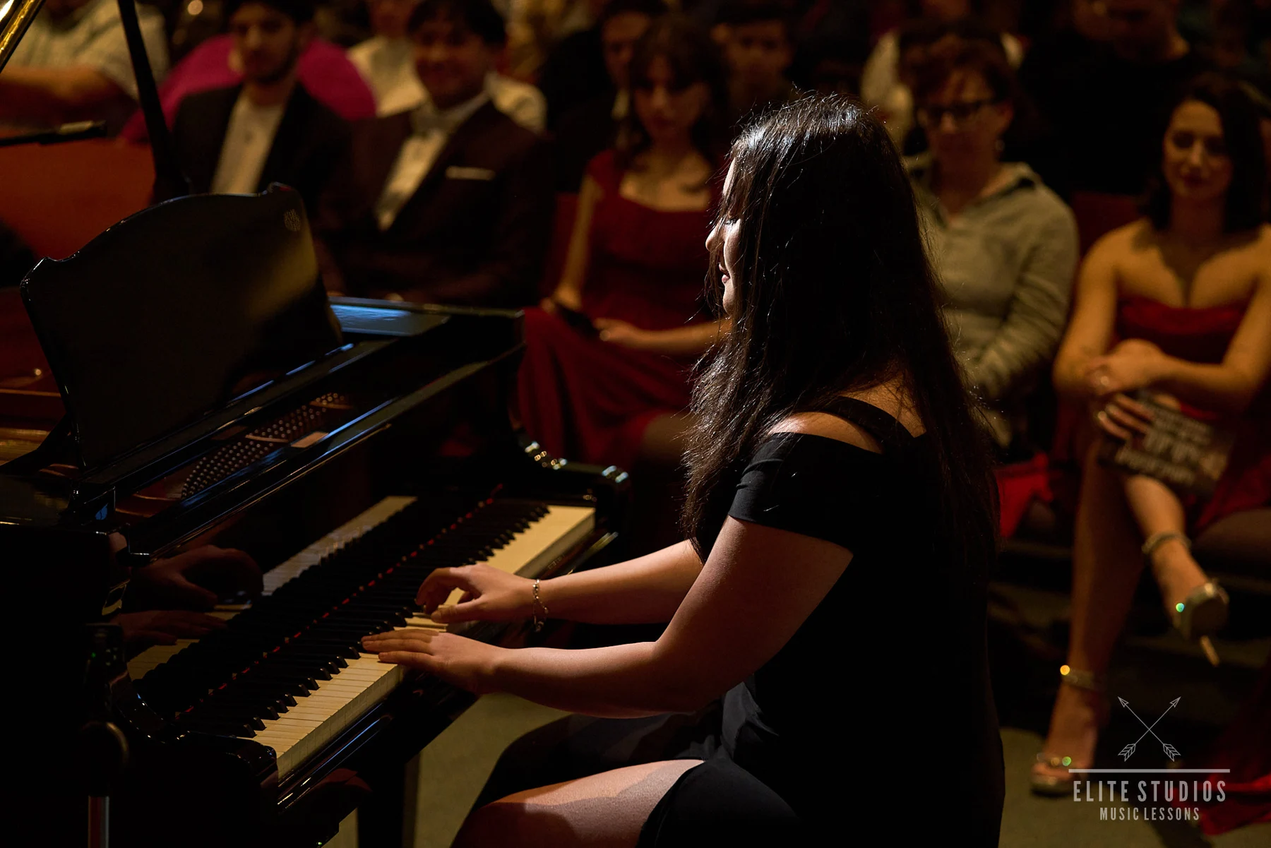 A pianist performing for an audience at an Elite Studios showcase
