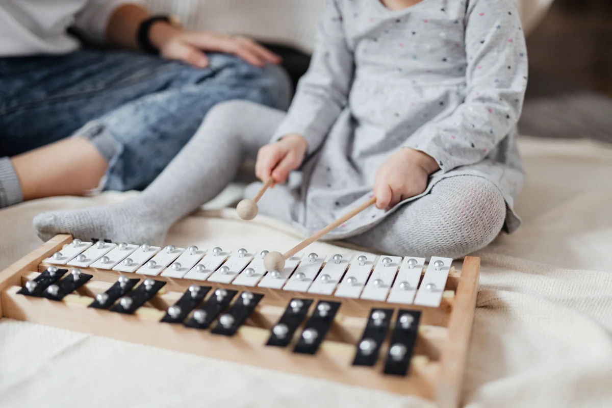A child exploring notes on a metallophone