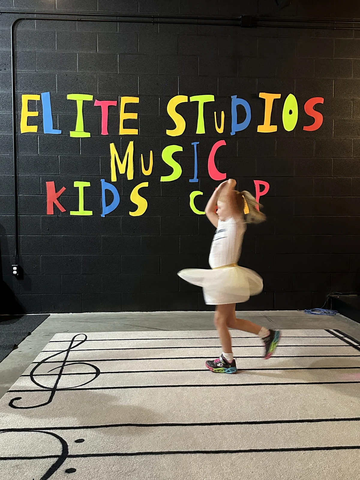 A child dancing in the Elite Studios music camp space
