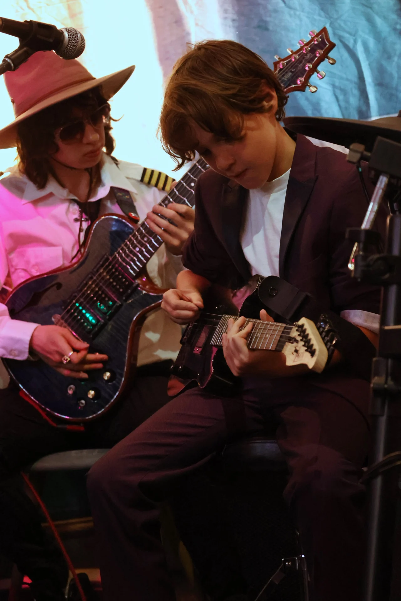 Two Elite Studios guitarists playing together on stage