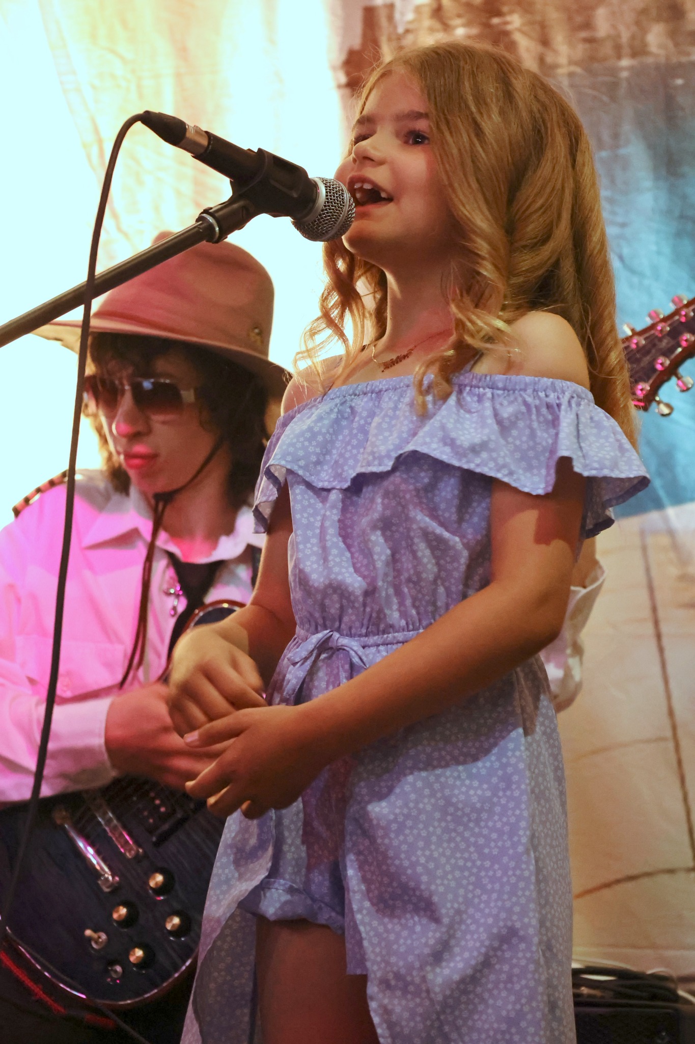 A young Elite Studios performer singing on stage